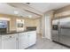 Open kitchen area featuring a bar seating area, stainless steel refrigerator, and white cabinets at 2730 Woodland Hills Ave, Lakeland, FL 33803