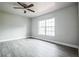 Bright bedroom with light gray walls, wood-look floors, ceiling fan and large window at 2370 Sw 146Th Loop, Ocala, FL 34473