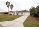 View of the house with long driveway and a well-manicured lawn at 2370 Sw 146Th Loop, Ocala, FL 34473