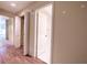 Hallway featuring wood-look flooring, several white doors and views into other rooms at 3808 Ne 17Th St # 3808, Ocala, FL 34470