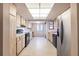 Well-lit kitchen featuring wood-look cabinets, a black stove, and a stainless steel refrigerator at 3808 Ne 17Th St # 3808, Ocala, FL 34470