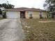 Front exterior view of single story tan home with a one car garage and front lawn at 605 Van Ness St, Daytona Beach, FL 32114