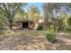 Backyard featuring green grass, sheds, wooded area, and an open garage space at 5670 Sw 34Th St, Ocala, FL 34474
