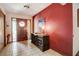 Inviting foyer with a red accent wall, tile flooring, and a decorative wood entry door at 5670 Sw 34Th St, Ocala, FL 34474