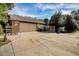 Exterior shot of garage featuring a large driveway, partial wooden fence, and blue recycling bins at 5670 Sw 34Th St, Ocala, FL 34474