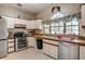 An L-shaped kitchen featuring tile flooring, a window, modern appliances, and wooden countertops at 5670 Sw 34Th St, Ocala, FL 34474