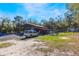 Exterior view of a charming property with a covered shelter, truck, and green surroundings at 12308 Se 112Th Avenue Rd, Belleview, FL 34420