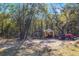 View of property including small metal awning, tarp tent, and red tractor at 12308 Se 112Th Avenue Rd, Belleview, FL 34420