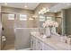 Bathroom featuring double vanity, stone countertops, glass-enclosed shower, and modern lighting at 16198 Honey Harvest St, Winter Garden, FL 34787