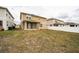 Back exterior view of a two-story home with a fenced backyard and a covered patio at 348 Lake Smart Cir, Winter Haven, FL 33881
