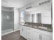 Bright bathroom featuring double sinks, a large mirror, and a glass-enclosed shower with gray tiles at 348 Lake Smart Cir, Winter Haven, FL 33881