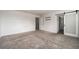A large, open bedroom with neutral carpet and a modern barn door leading to the bathroom at 348 Lake Smart Cir, Winter Haven, FL 33881