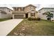 Two-story home with tan siding, red shutters, a brown garage door, and a well-manicured front lawn at 348 Lake Smart Cir, Winter Haven, FL 33881