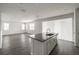 Open floor plan featuring an island with sink and cabinets, wood-look floors, and a large window at 348 Lake Smart Cir, Winter Haven, FL 33881