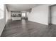 Spacious living area with wood-look floors, an open floorplan, and a kitchen in background at 348 Lake Smart Cir, Winter Haven, FL 33881