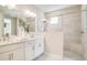 Modern bathroom featuring double vanity sinks, a large mirror, and a tiled walk-in shower with glass enclosure at 5260 Stone Ridge Pl, St Cloud, FL 34771