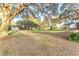 Large backyard with mature trees, covered in leaves, and a detached garage at 725 Giant Oak Rd, Lakeland, FL 33810