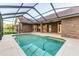 Enclosed swimming pool featuring a brick home, screened-in enclosure, and travertine decking at 725 Giant Oak Rd, Lakeland, FL 33810