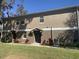 View of the side of the tan home, landscaping, and covered entrances at 1555 Scarlet Oak Loop # 113A, Winter Garden, FL 34787