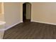Empty living room area with hardwood flooring leading to an arched hallway at 1555 Scarlet Oak Loop # 113A, Winter Garden, FL 34787