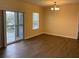 Bright living room with hardwood floors and a sliding glass door to the patio at 1555 Scarlet Oak Loop # 113A, Winter Garden, FL 34787