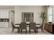 Elegant dining room with a wooden table, fabric chairs, modern lighting, and view into kitchen area for easy serving at 4791 Waltham Forest Dr, Davenport, FL 33837