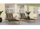 Relaxing patio with two lounge chairs, side table, potted plants, and a view through to the interior with bright light at 4791 Waltham Forest Dr, Davenport, FL 33837