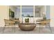 Inviting patio with stylish wicker chairs, a round metal coffee table, and views of the interior living spaces at 4791 Waltham Forest Dr, Davenport, FL 33837