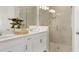 Bathroom with a double sink vanity, white cabinets, and a glass-enclosed shower at 5190 Goldfinch Dr, St Cloud, FL 34771