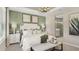 Well-lit main bedroom with a king-size bed, decorative wall art, and access to the ensuite bathroom at 5190 Goldfinch Dr, St Cloud, FL 34771