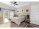 Airy bedroom with a white bed, french doors, and a comfortable chair on top of a red rug at 7615 Heritage Crossing Way # 102, Reunion, FL 34747