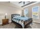 Relaxing bedroom features a queen bed with blue plaid comforter, neutral walls, and sunny windows with blinds at 7615 Heritage Crossing Way # 102, Reunion, FL 34747