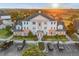 Stunning three-story building with manicured landscaping and ample parking at sunset at 7615 Heritage Crossing Way # 102, Reunion, FL 34747