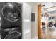 Convenient laundry area features stacked Samsung washer and dryer set and access to an adjacent living space at 7615 Heritage Crossing Way # 102, Reunion, FL 34747
