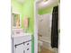 Small bathroom with green walls has white cabinets, a toilet, and a shower at 848 Casselberry Dr, Lake Wales, FL 33853