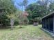 Backyard view from house features a screened porch, blooming tree, storage shed, and picnic tables at 24605 Ne 177Th Ter, Fort Mc Coy, FL 32134