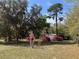 Backyard featuring flowering bushes and outbuilding that enhance the property's appeal at 24605 Ne 177Th Ter, Fort Mc Coy, FL 32134