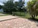 Brick patio area leading to a spacious backyard with mature trees and lush green grass at 24605 Ne 177Th Ter, Fort Mc Coy, FL 32134