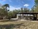 Property featuring an outdoor covered area with picnic table, adjacent to the home at 24605 Ne 177Th Ter, Fort Mc Coy, FL 32134
