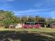 Charming home exterior surrounded by lush landscaping and mature trees at 24605 Ne 177Th Ter, Fort Mc Coy, FL 32134