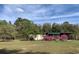 Exterior featuring flowering bushes and trees at 24605 Ne 177Th Ter, Fort Mc Coy, FL 32134