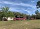 Exterior featuring flowering bushes and trees at 24605 Ne 177Th Ter, Fort Mc Coy, FL 32134