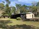 Charming home featuring a sunroom and stone foundation, surrounded by lush greenery at 24605 Ne 177Th Ter, Fort Mc Coy, FL 32134