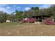 Exterior of house with carport and picnic table, framed by vibrant azalea bushes at 24605 Ne 177Th Ter, Fort Mc Coy, FL 32134