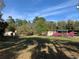 Sprawling front yard showcasing the house, carport, secondary structure, and mature trees at 24605 Ne 177Th Ter, Fort Mc Coy, FL 32134