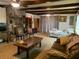 Open living space with wood beam ceiling, stone fireplace, and view of a comfortable bed at 24605 Ne 177Th Ter, Fort Mc Coy, FL 32134