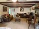 Inviting living room with exposed beams, a stone fireplace, and ample seating for entertaining at 24605 Ne 177Th Ter, Fort Mc Coy, FL 32134