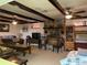 Comfortable living room with exposed beams, a stone fireplace, and classic furnishings at 24605 Ne 177Th Ter, Fort Mc Coy, FL 32134