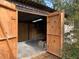 Open doors reveal the shed's interior, which has plywood walls, brick flooring, and an overhead light at 24605 Ne 177Th Ter, Fort Mc Coy, FL 32134