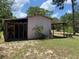 Exterior view of a storage shed with a covered area, offering practical space for outdoor equipment or hobbies at 24605 Ne 177Th Ter, Fort Mc Coy, FL 32134